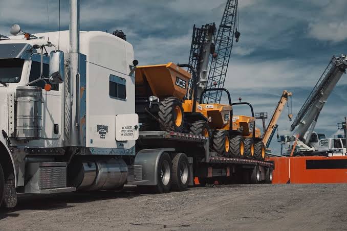 Drop deck trailer loaded with two JCB site dumpers.